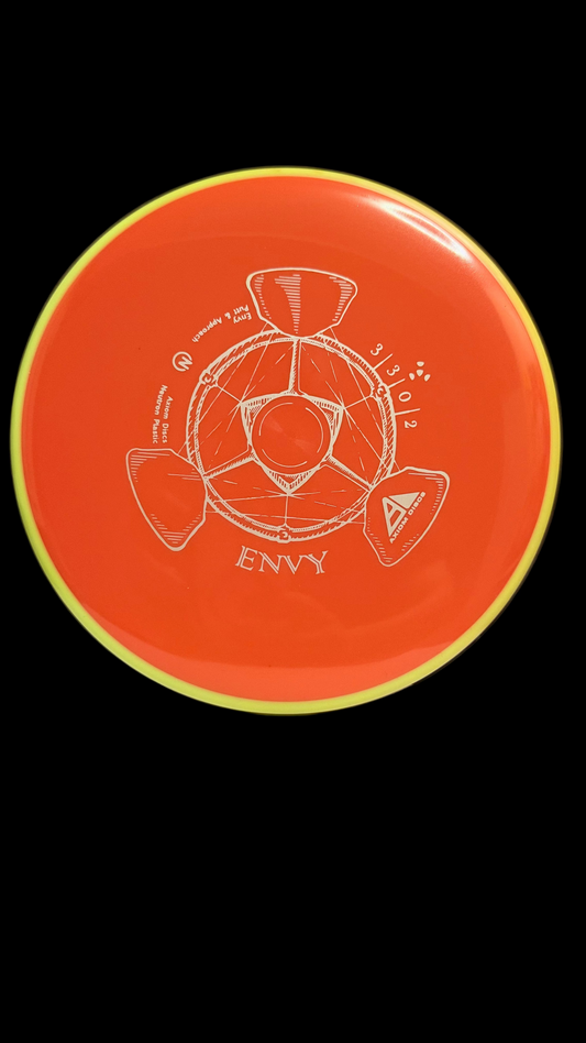 Axiom Neutron Envy orange putt & approach disc with yellow rim, showcasing the 3 | 3 | 0 | 2 flight numbers and the detailed Envy stamp artwork