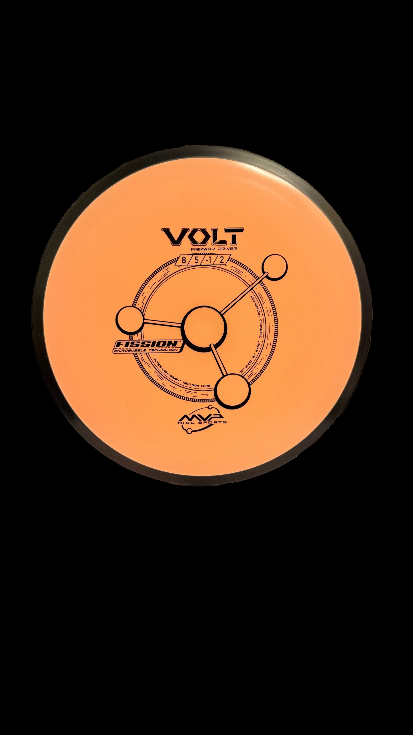 MVP Fission Volt disc golf driver in peach color with black rim, displayed upright on a stand against a neutral indoor background. Flight numbers 8 | 5 | -1 | 2 are visible along with the Fission microbubble technology stamp.