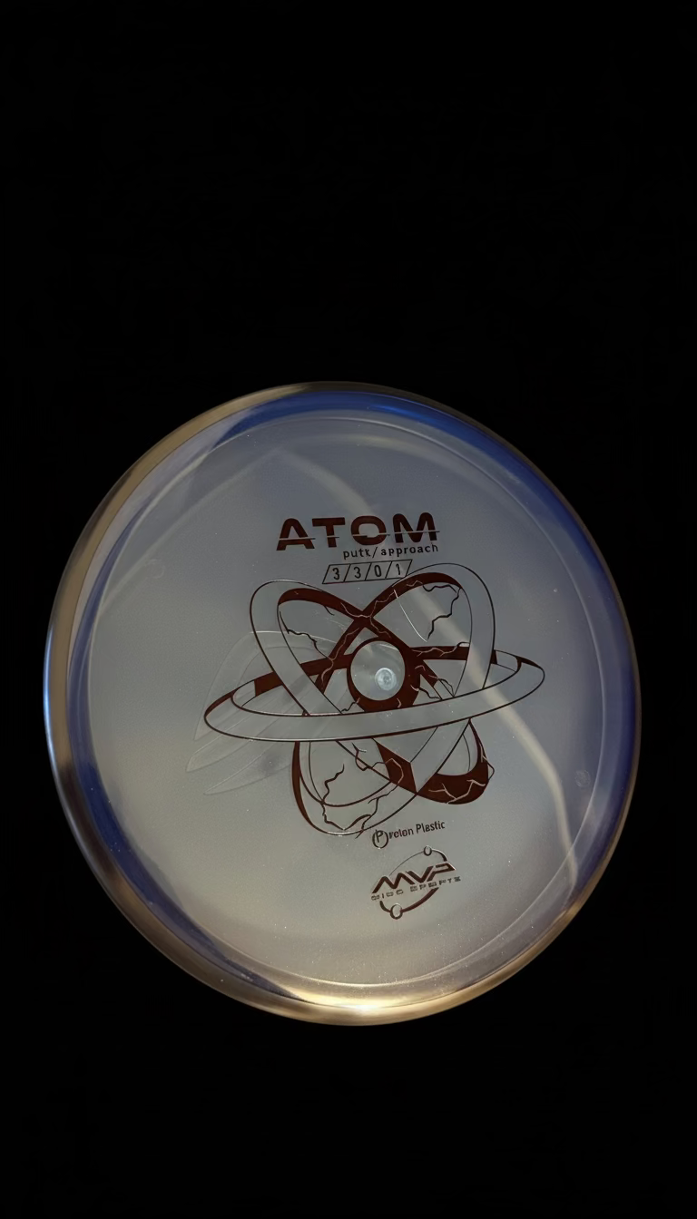 Clear blue MVP Proton Atom putt and approach disc with a black rim and black atomic-style graphic stamp.