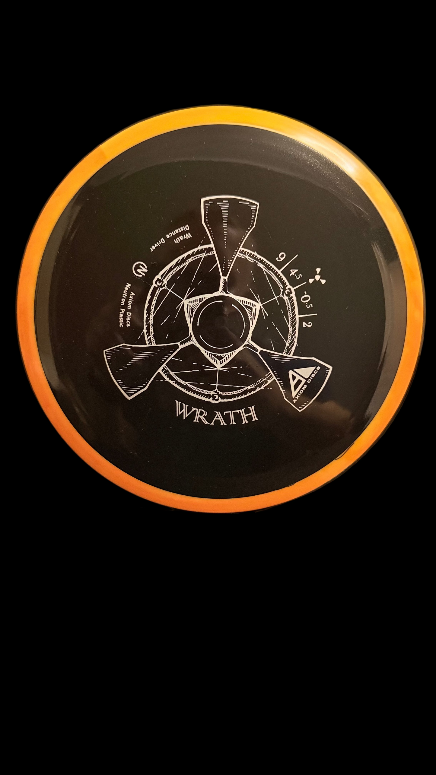 Axiom Neutron Wrath black distance driver with orange rim on a stand