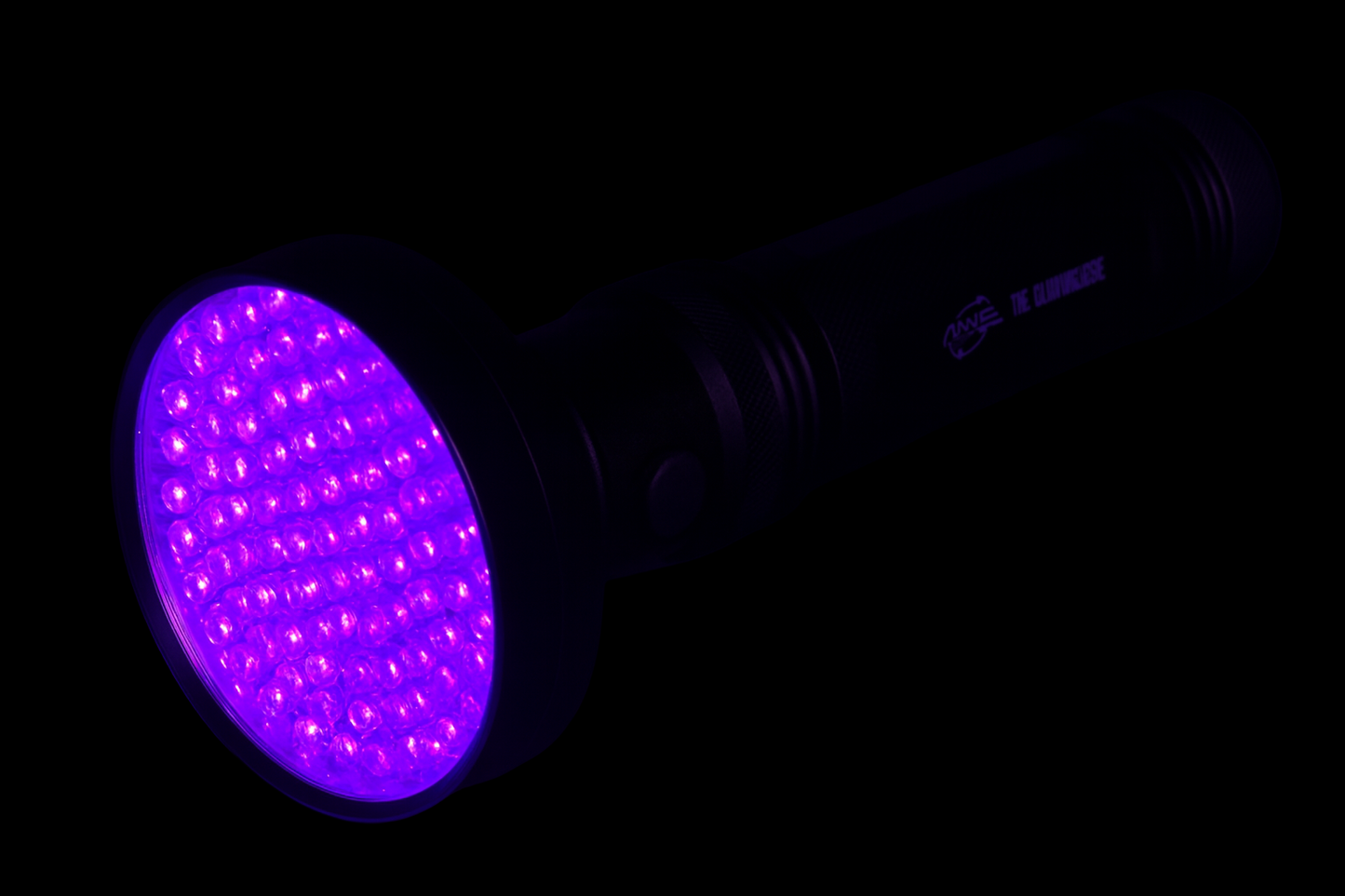 Black MVP UV flashlight glowing with bright ultraviolet light onto a dark surface, highlighting its LED array and showing it is designed for charging glow plastic